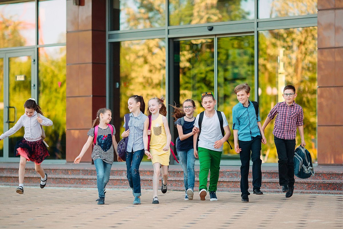 Fröhliche Gruppe von Kindern kommt aus der Schule.