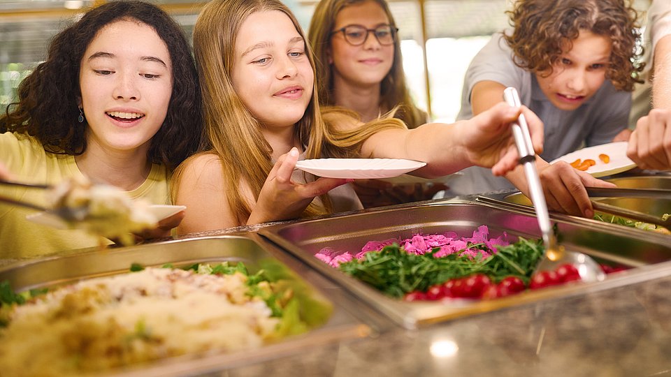Kinder bedienen sich selbst am Buffet in der Schulmensa