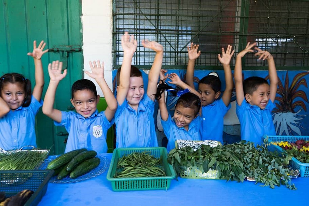 Kinder in einem Schulgarten in El Salvador.
