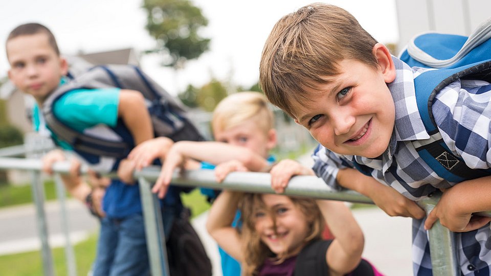 Grundschulkinder spielen auf dem Schulhof.  