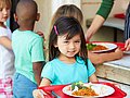 Schulkinder holen sich ein gesundes Mittagessen in der Schule. 