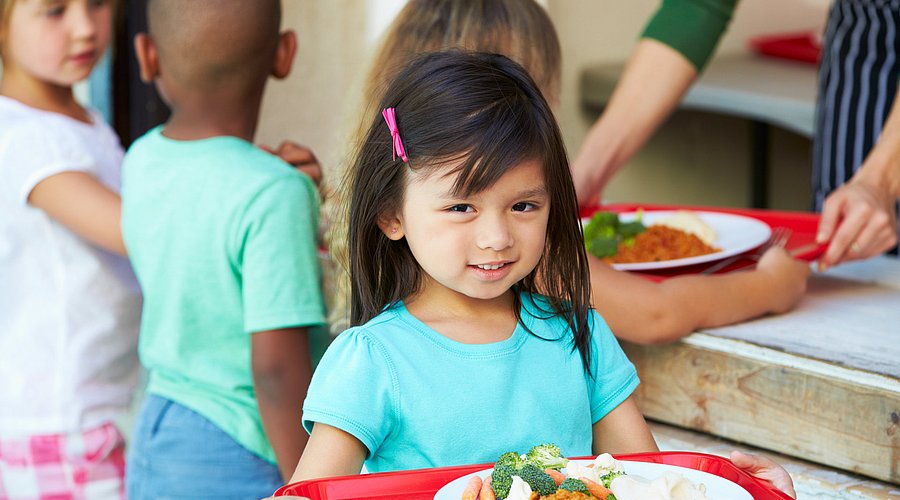 Schulkinder holen sich ein gesundes Mittagessen in der Schule. 