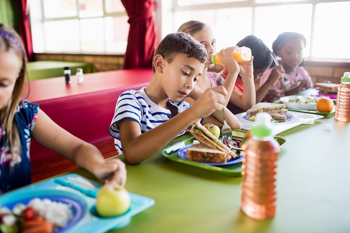 Kinder beim Mittagessen in der Schulmensa