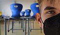 Jugendlicher Schüler mit Maske im Klassenraum