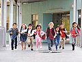 Grundschulkinder laufen über den Flur einer Schule.