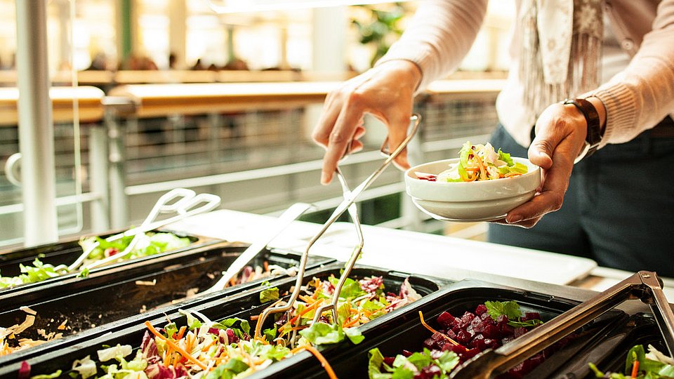 Eine Studentin bedient sich am Salatbuffet. 