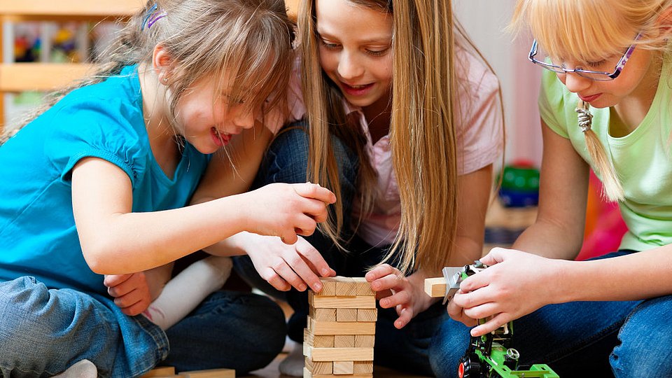 Mädchen spielen das Spiel Yenga.   