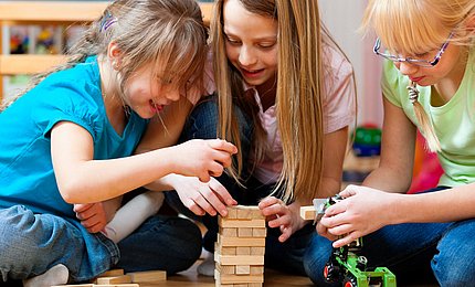 Mädchen spielen das Spiel Yenga.   