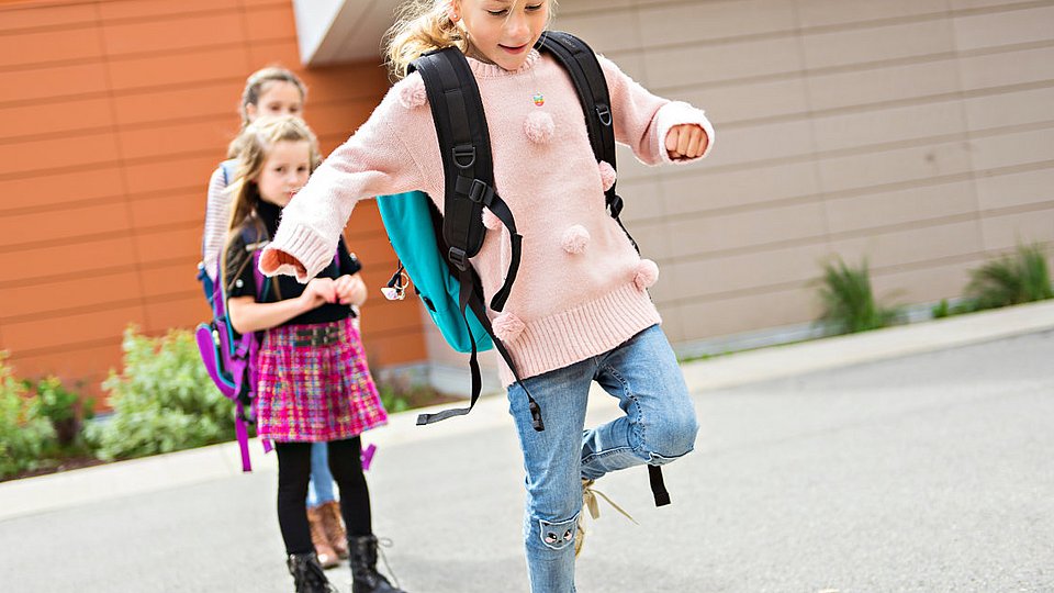 Schulkinder spielen ein Bewegungsspiel auf dem Schulhof. 