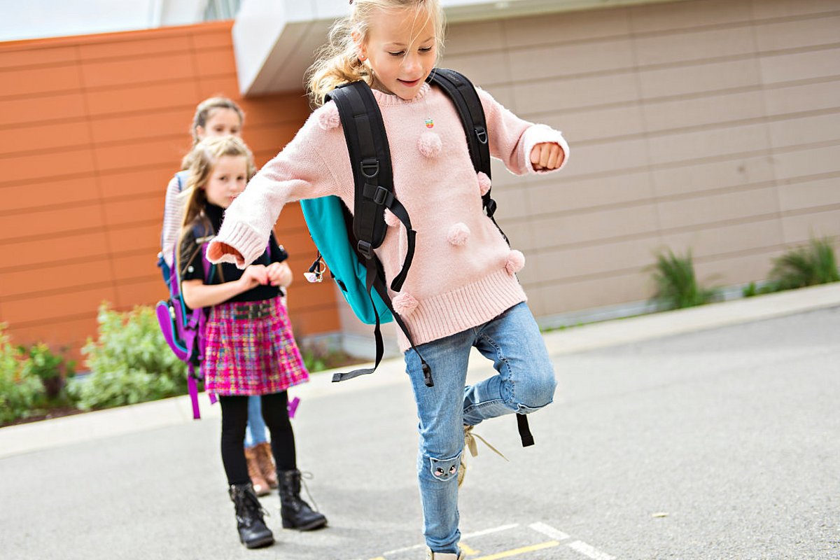 Schulkinder spielen ein Bewegungsspiel auf dem Schulhof. 