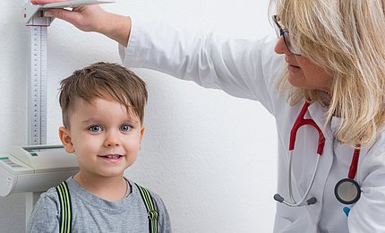 Eine Ärztin führt eine Schuleingangsuntersuchung bei einem Vorschulkind durch. 