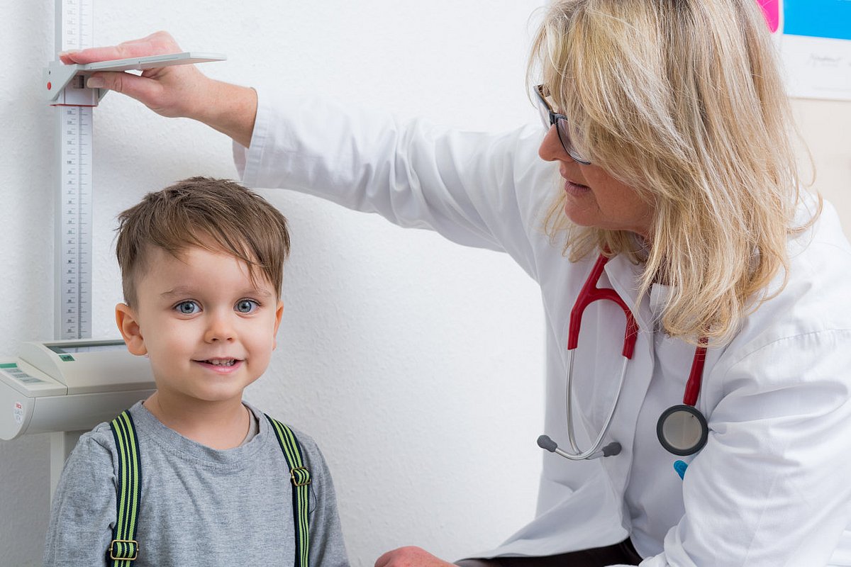 Eine Ärztin führt eine Schuleingangsuntersuchung bei einem Vorschulkind durch. 