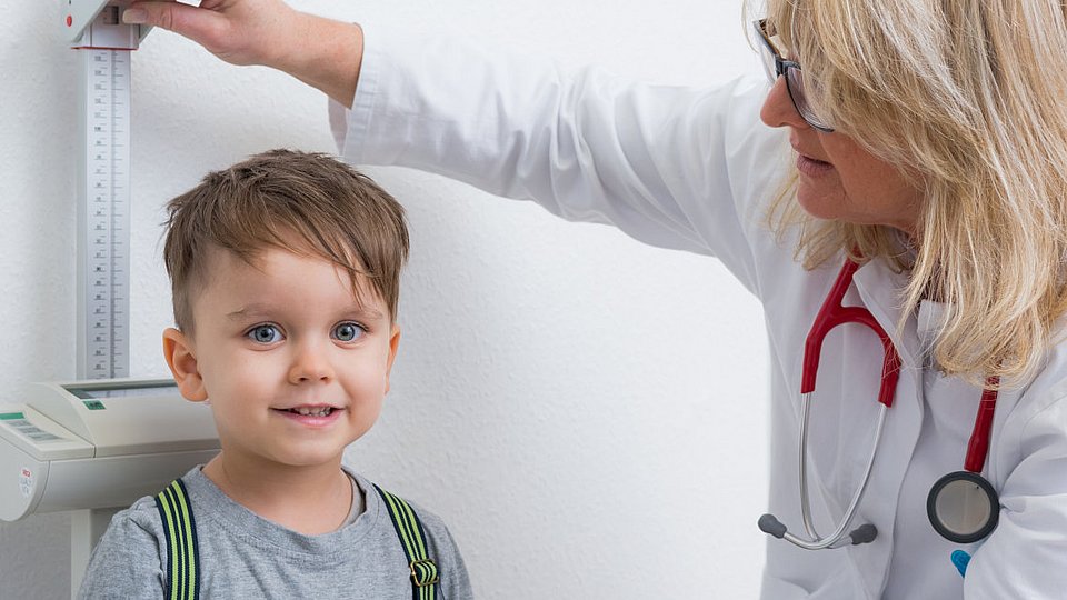 Eine Ärztin führt eine Schuleingangsuntersuchung bei einem Vorschulkind durch. 