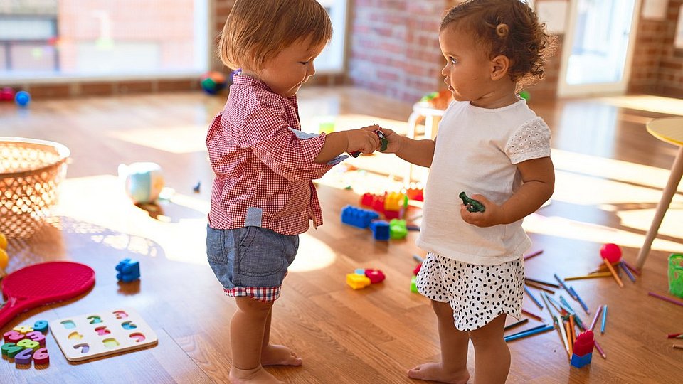 Zwei Kleinkinder, die miteinander spielen. 