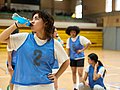 Basketballerin trinkt ein Erfrischungsgetränk aus einer Flasche auf dem Spielfeld.