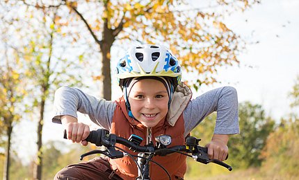 Eine Junge sitzt auf einem Fahrrad.