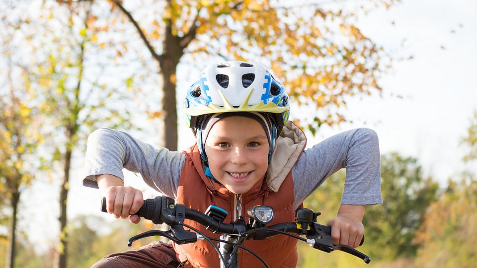 Eine Junge sitzt auf einem Fahrrad.
