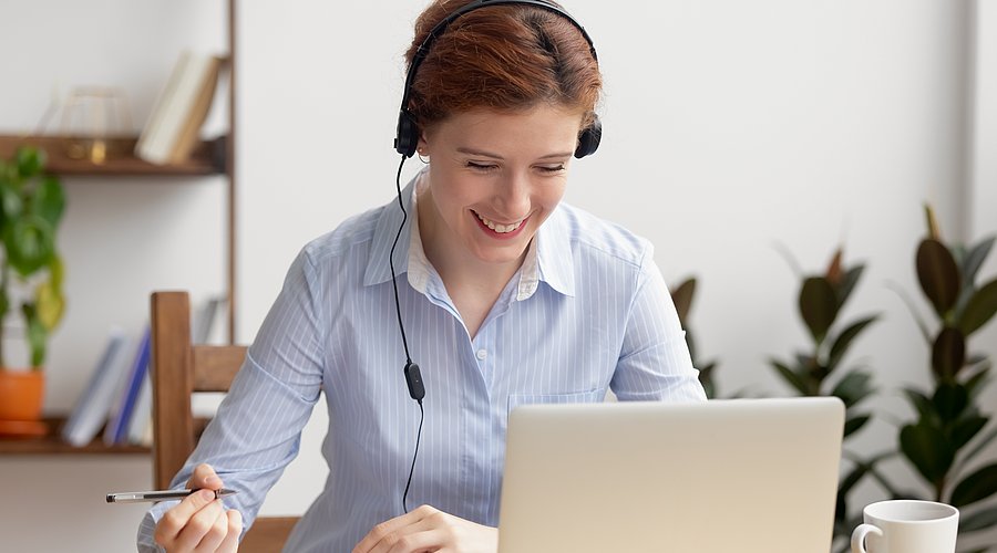 Eine Frau sitzt am Arbeitsplatz und betreibt Selbststudium 