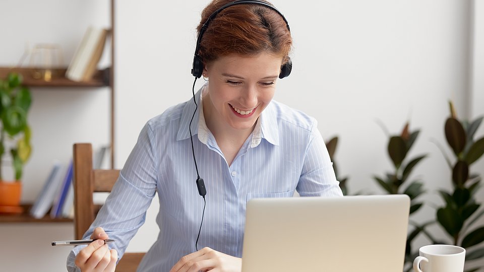 Eine Frau sitzt am Arbeitsplatz und betreibt Selbststudium 