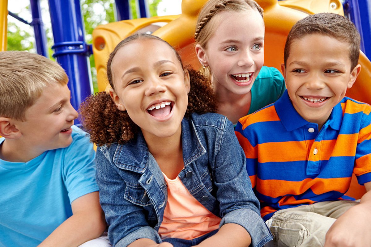 Lachende Kinder spielen im Freien auf dem Spielplatz. 