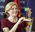 Bundesernährungsministerin Julia Klöckner hält die Trophäe für den Schulwettbewerb Echt kuh-l in der Hand.