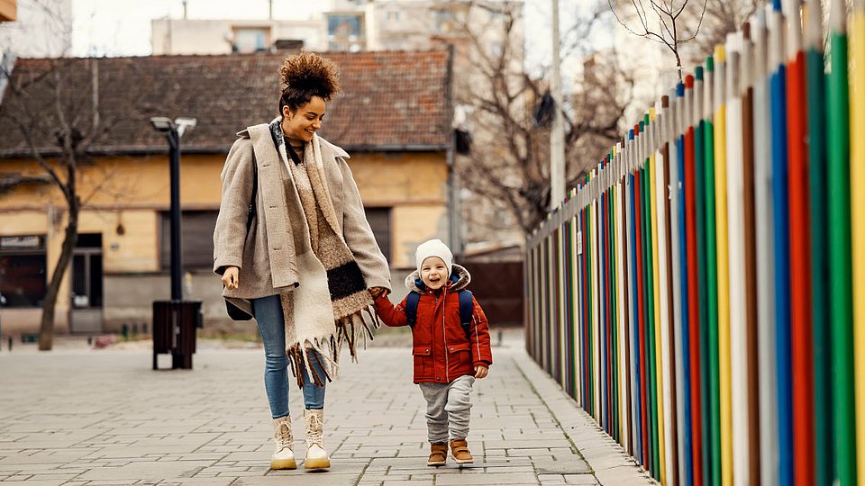 Mutter geht mit ihrem Kind zur Vorschule.