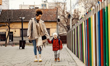 Mutter geht mit ihrem Kind zur Vorschule.