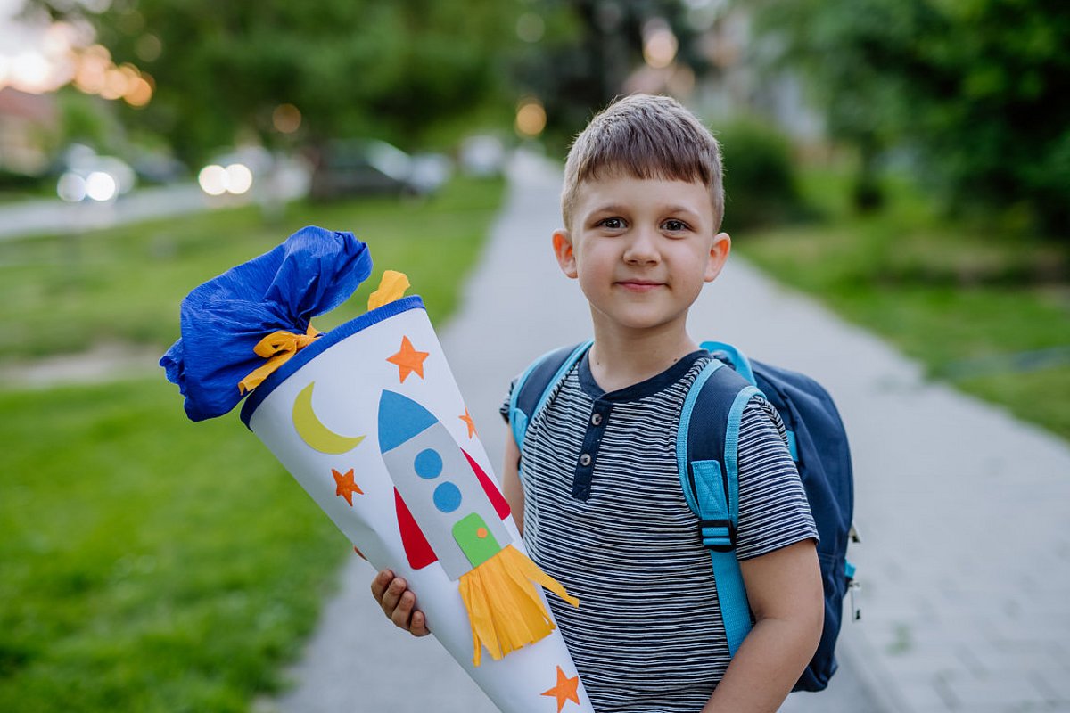 Schulkind mit Schultüte am ersten Schultag. 