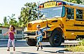 Zwei Schulkinder vor einem US-amerikanischen Schulbus