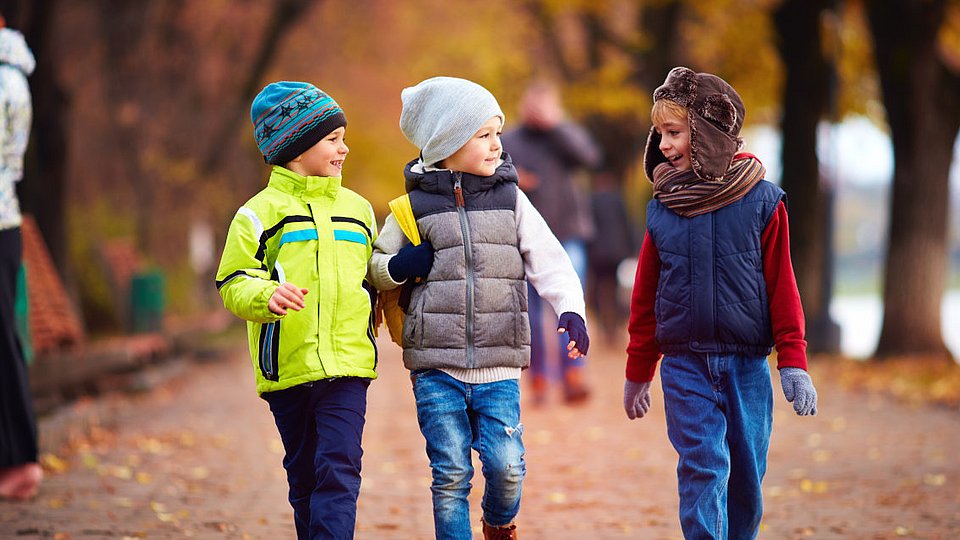 Drei Schulkinder im herbstlichen Park. 