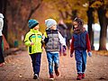 Drei Schulkinder im herbstlichen Park. 