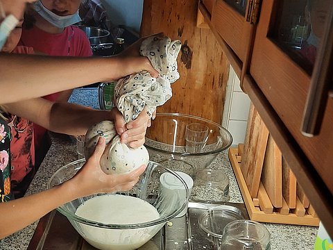 Kinder stellen in einer Schule Sojaquark selbst her. 