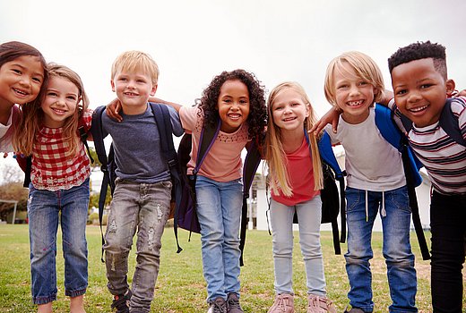 Grundschulkinder lachen in die Kamera. 