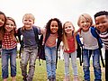 Grundschulkinder lachen in die Kamera. 