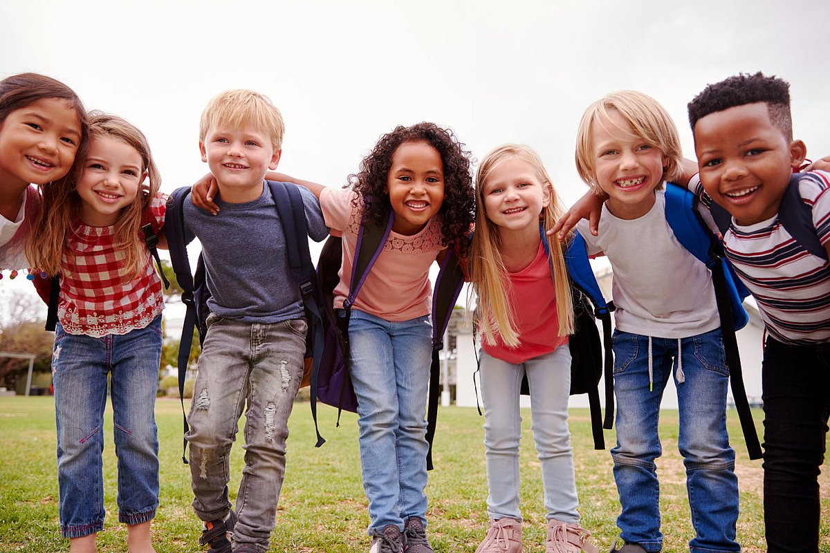 Grundschulkinder lachen in die Kamera. 