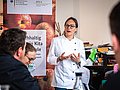 Auf einer Veranstaltung referiert eine Köchin über den Einsatz von Bio-Produkten in der Kita- und Schulverpflegung.
