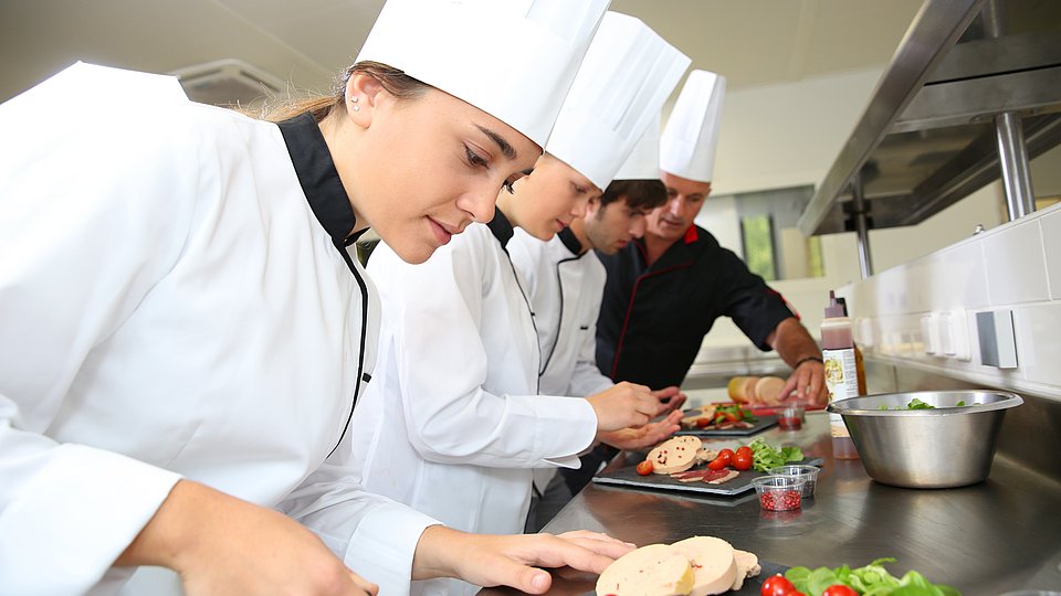 Köch*innen arbeiten in einer Großküche