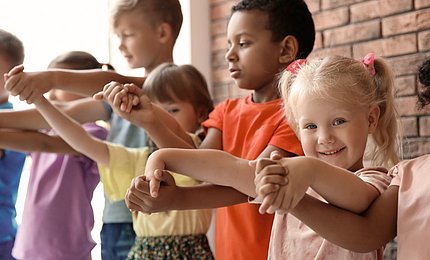 Kinder verschiedenen Alters halten sich an den Händen.