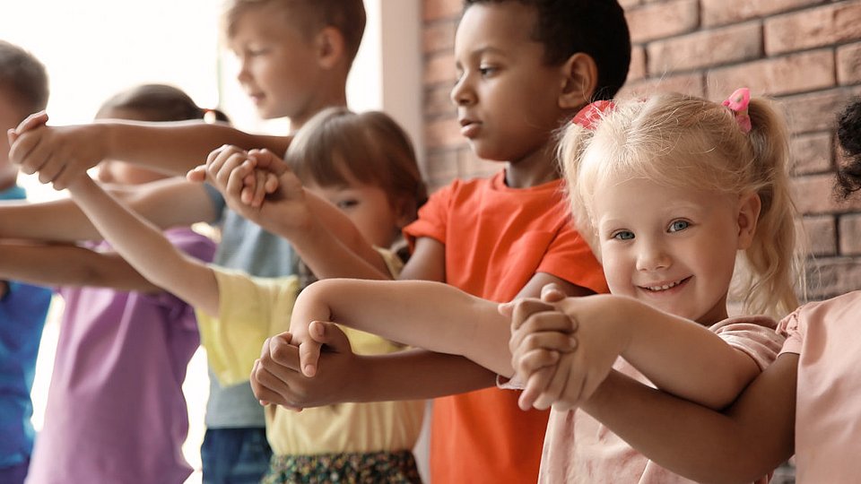 Kinder verschiedenen Alters halten sich an den Händen.