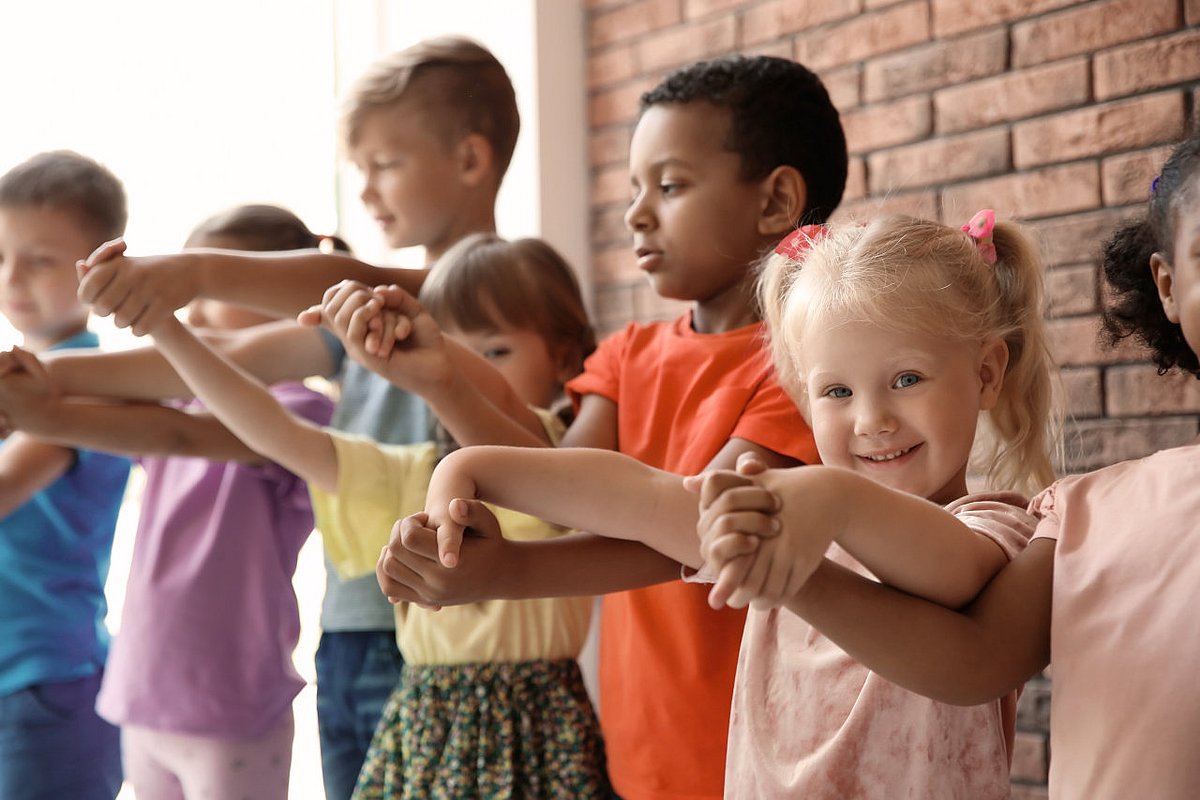 Kinder verschiedenen Alters halten sich an den Händen.