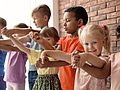 Kinder verschiedenen Alters halten sich an den Händen.