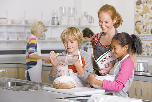 Lehrerin mit Schülern in der Küche