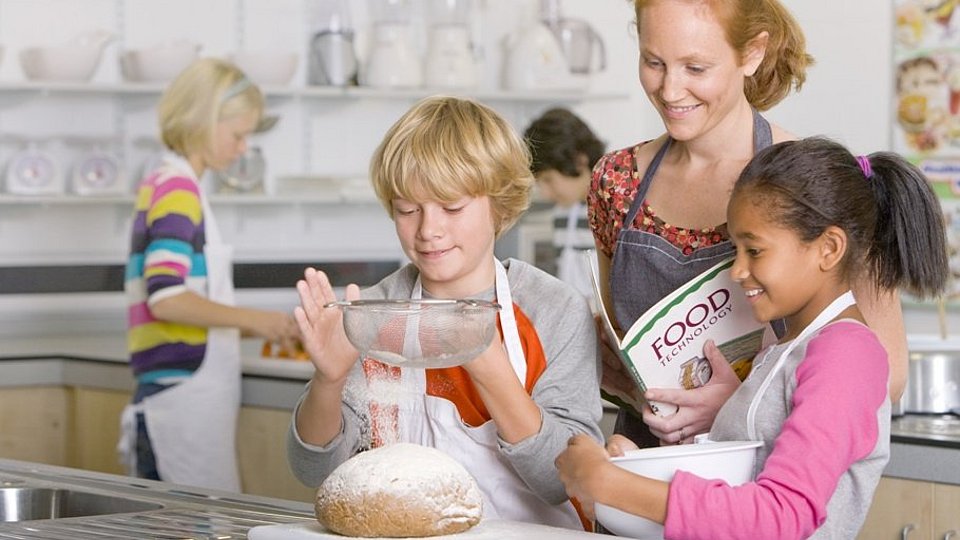 Lehrerin mit Schülern in der Küche