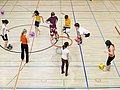 Schulklasse spielt Ballsport in der Sporthalle.