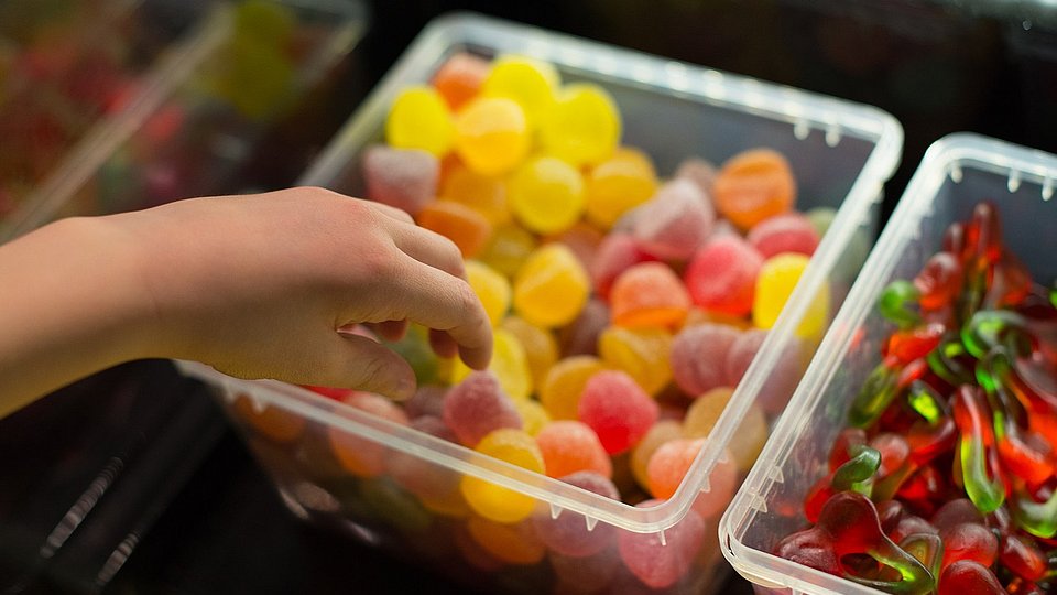 Kinderhand greift nach Süßigkeiten