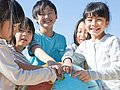 Schulkinder in Japan zeigen auf einem Globus, wo ihr Land liegt.