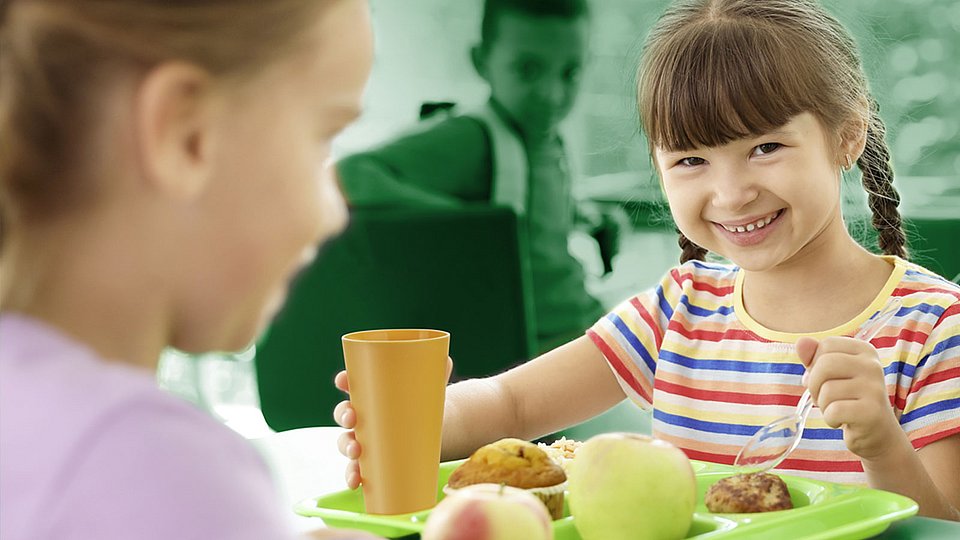Kinder beim Schulessen am Tisch