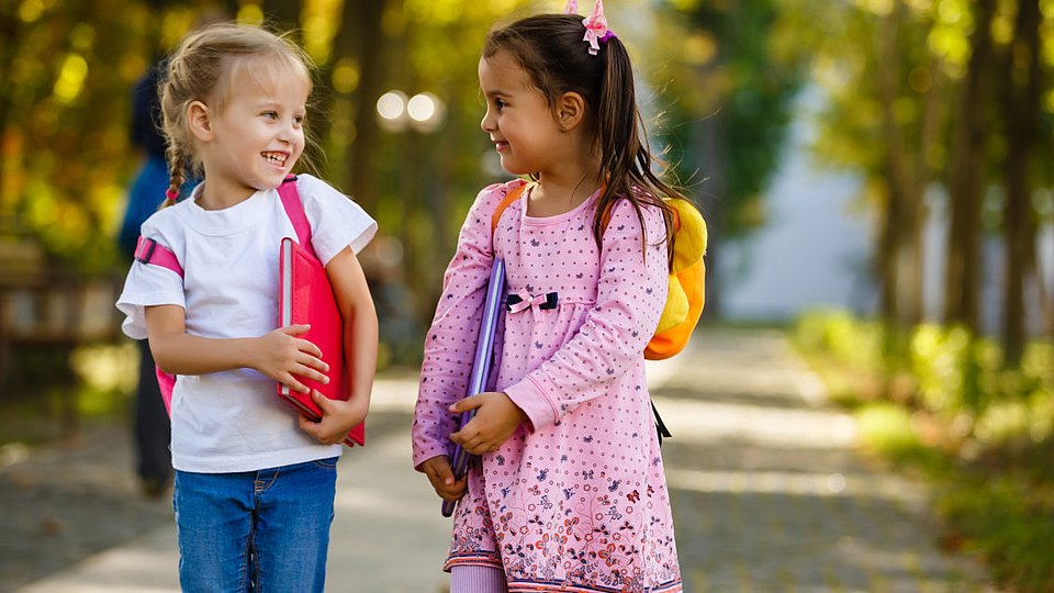 Zwei Kinder gehen zur Schule. 