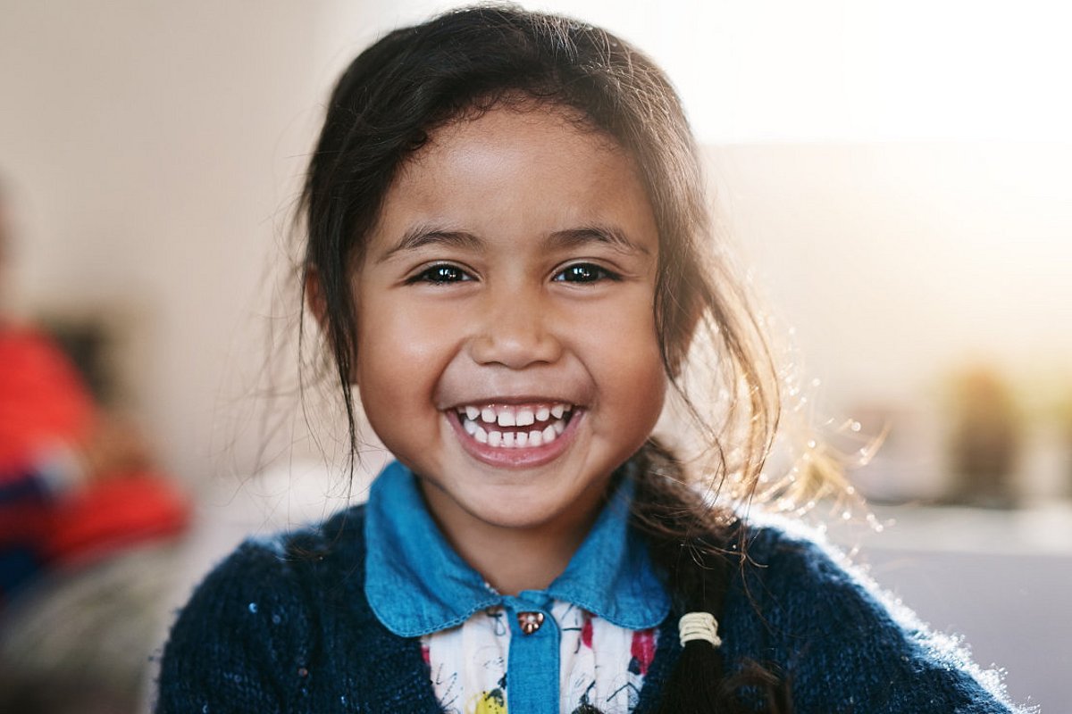 Brasilianisches Schulmädchen lacht in die Kamera.