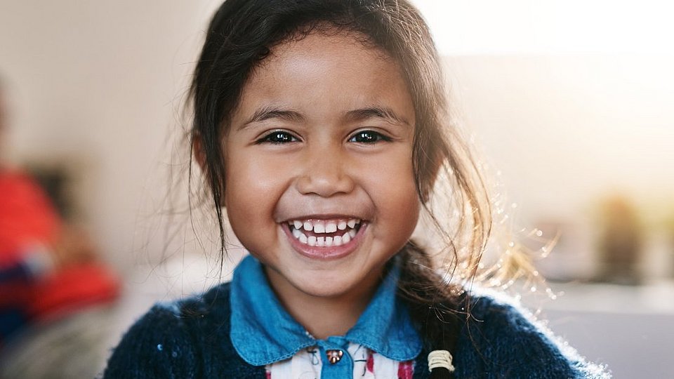 Brasilianisches Schulmädchen lacht in die Kamera.